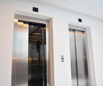 Two elevators in a building, one is open.